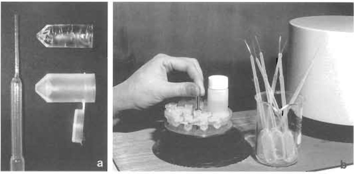 FIGURE 1 Freeze substitution in HM20. (a) Polyethylene Pasteur pipette with elongated tip (left), polyethylene capsule with hinged lid (lower right), and polymerized Lowicryl block after removal of capsule (upper right). (b) Holder with polyethylene capsules and vial for substitution fluid before being lowered into the Balzers FSU 010 freeze-substitution apparatus. To the right beaker with polyethylene Pasteur pipettes and to the far right part of a UV polymerization unit.