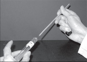 Inoculating a culture tube. Notice that the tube is held almost horizontally. Its cap is tucked in the little finger of